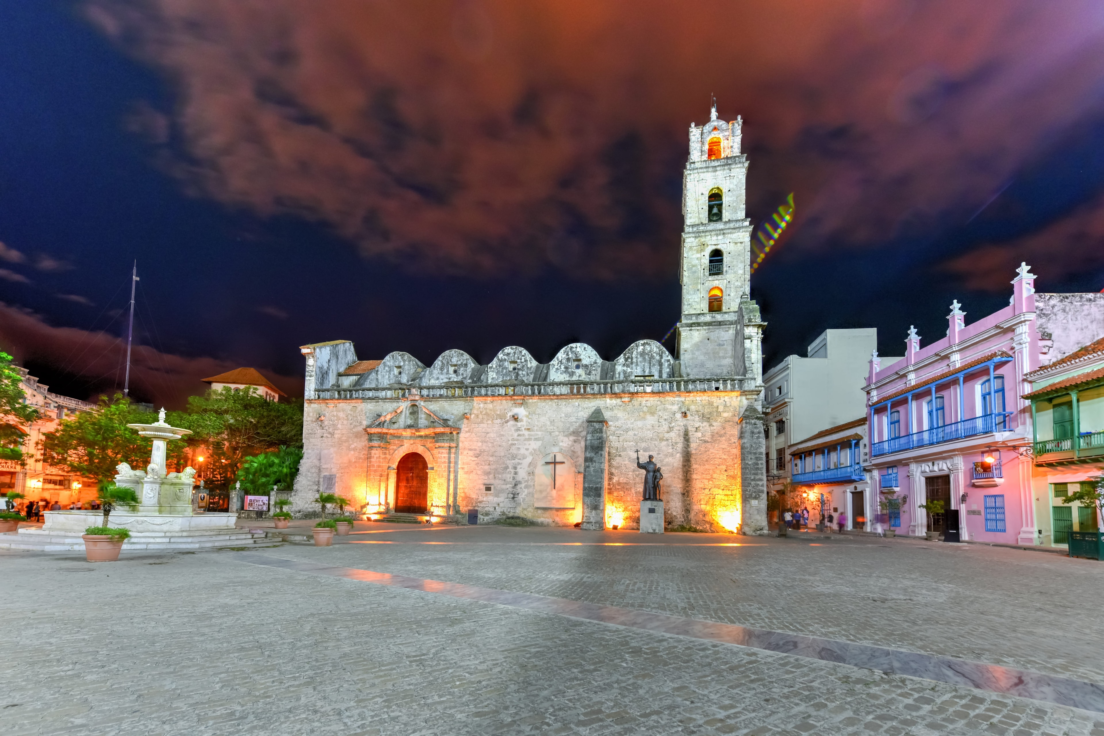 Iglesia de San Francisco de Asís illuminated at night on cobblestone plaza with fountain, Old Havana Cuba