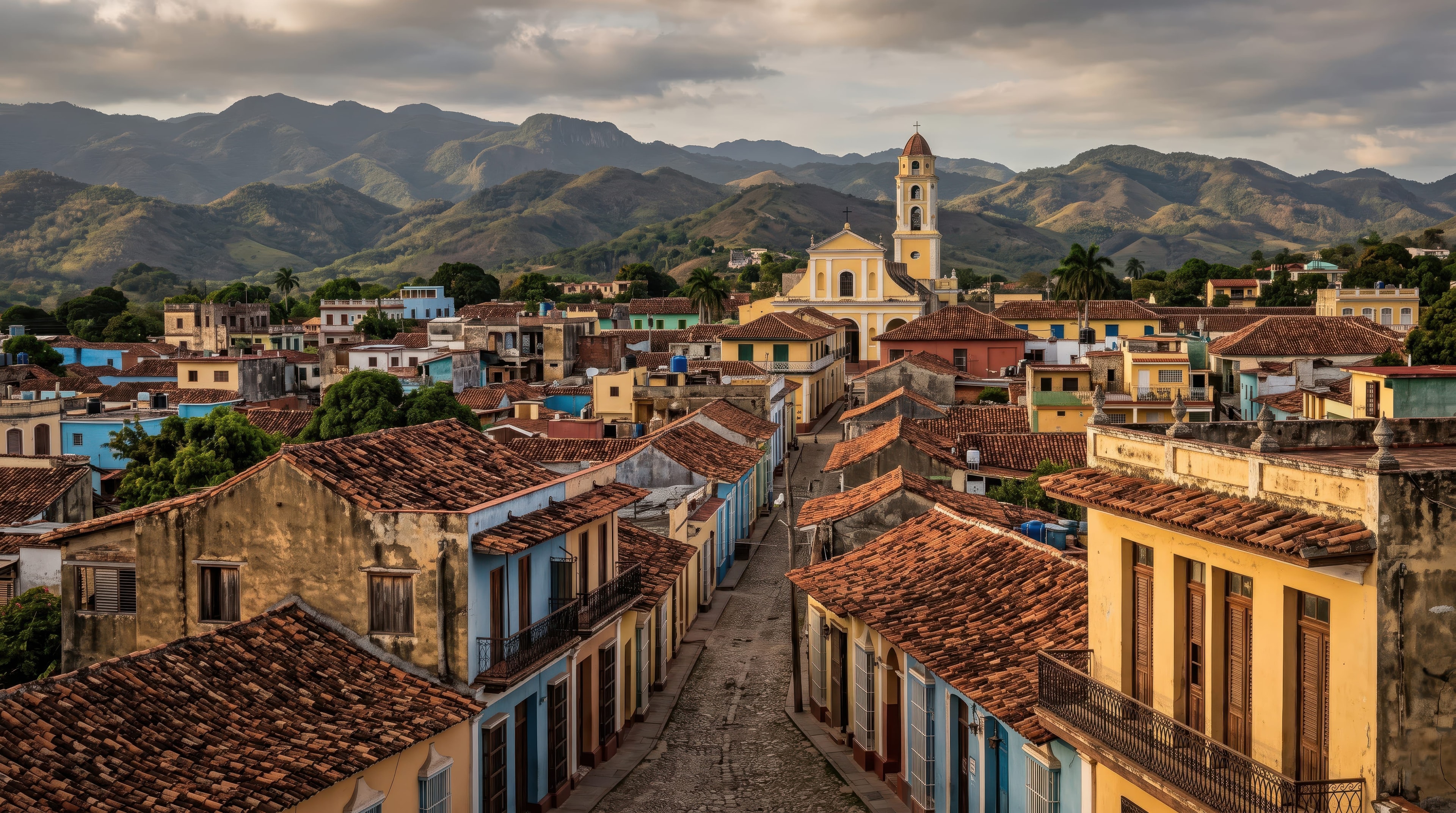 Trinidad Cuba rooftop panorama with terracotta tiles, yellow church bell tower, and Escambray mountains, Cuba