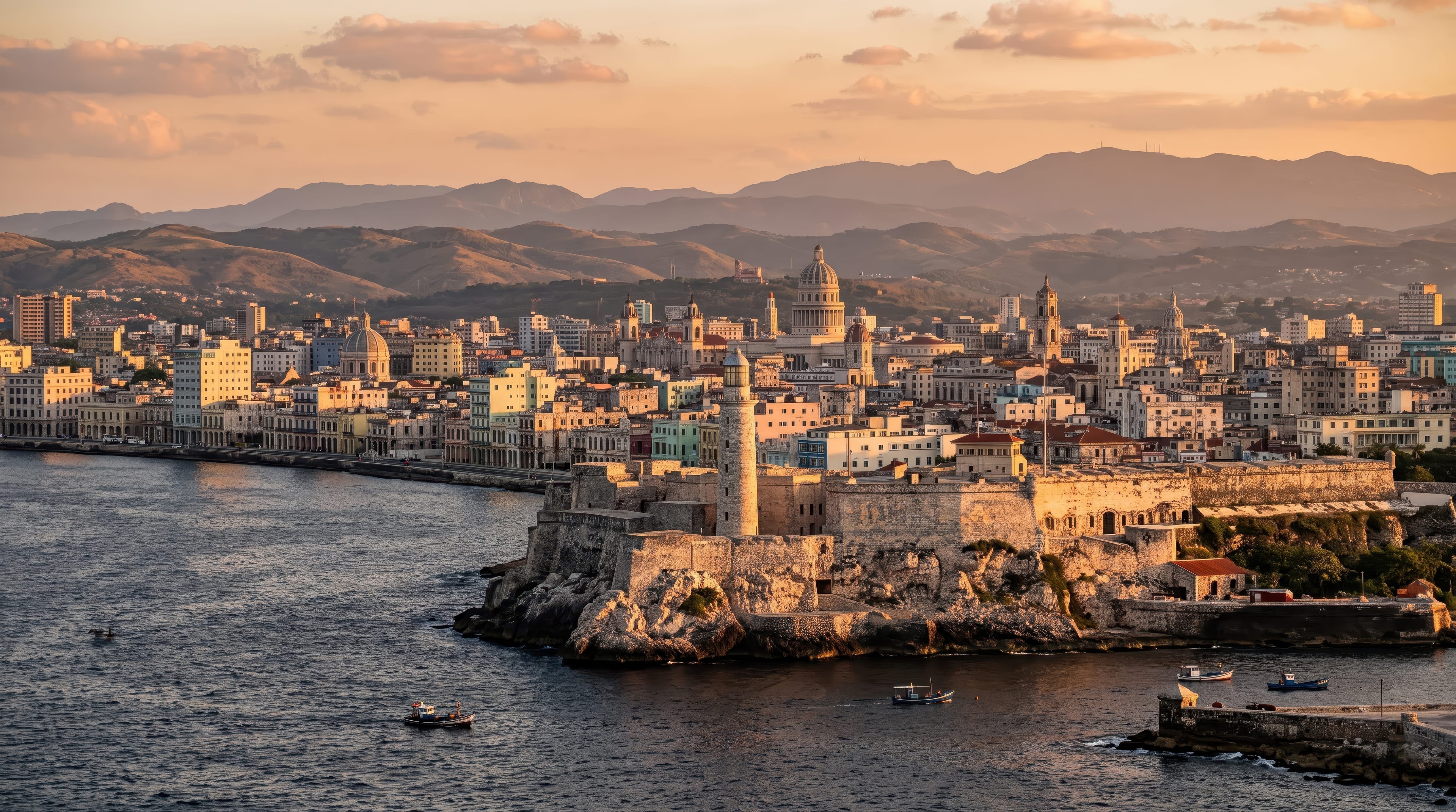 Aerial golden hour panorama of Havana harbor with Castillo del Morro lighthouse, city skyline, and mountains, Cuba