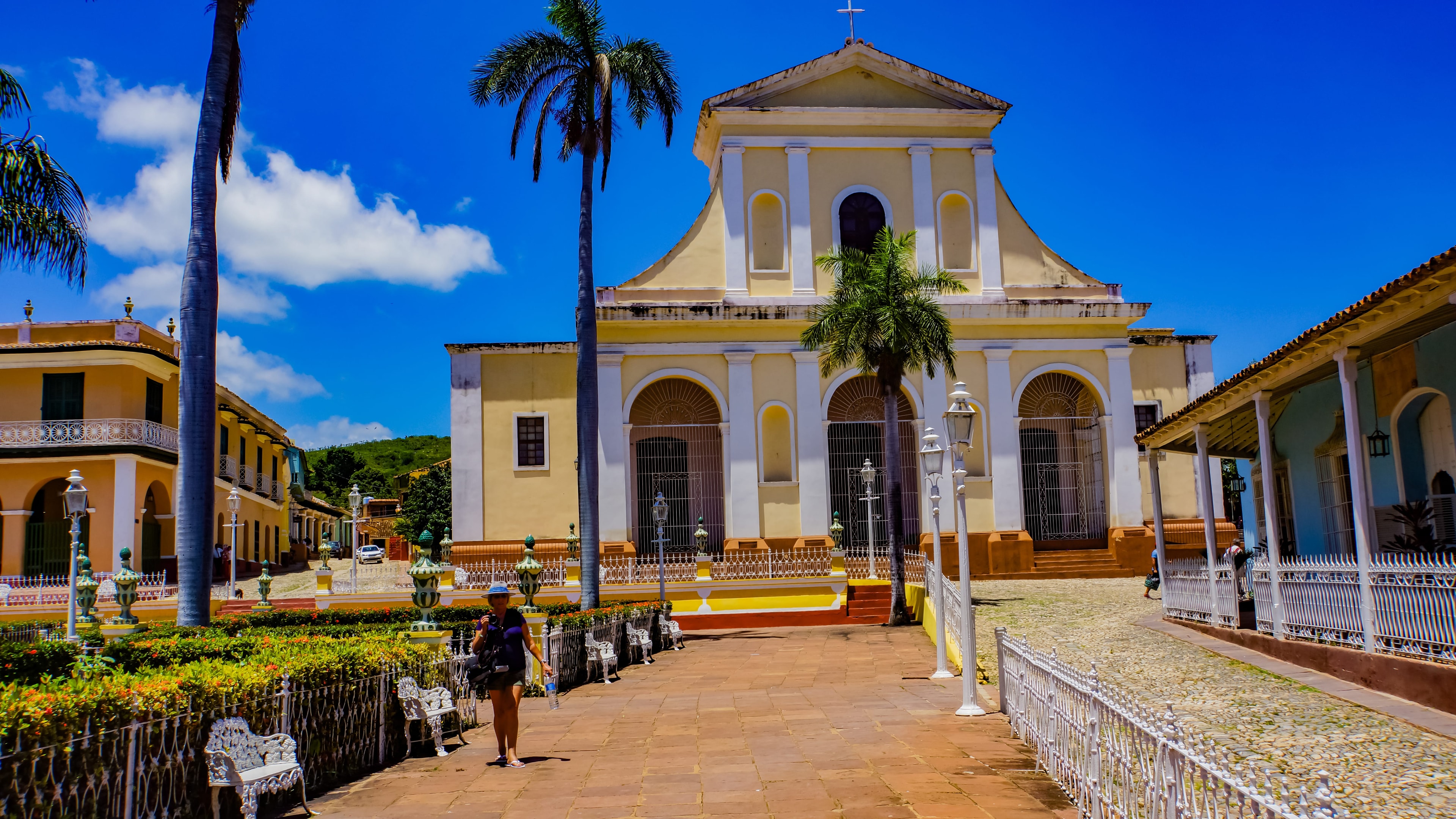 Iglesia Parroquial de la Santísima Trinidad yellow neoclassical church on Plaza Mayor with royal palms, Trinidad Cuba