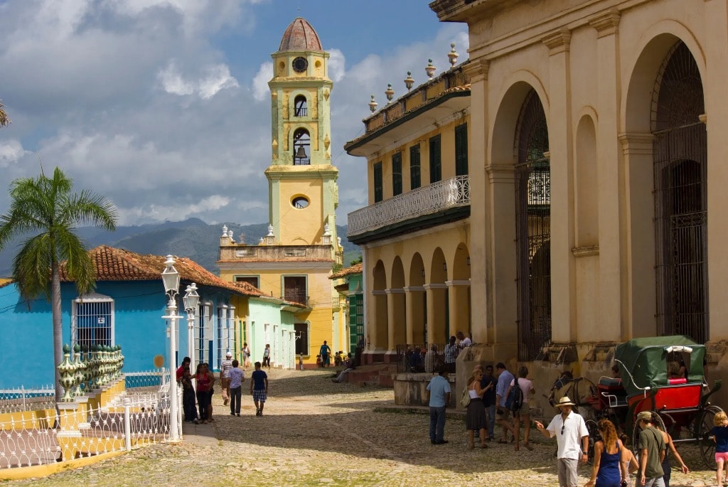 Trinidad Cuba colonial plaza with yellow bell tower and colorful buildings