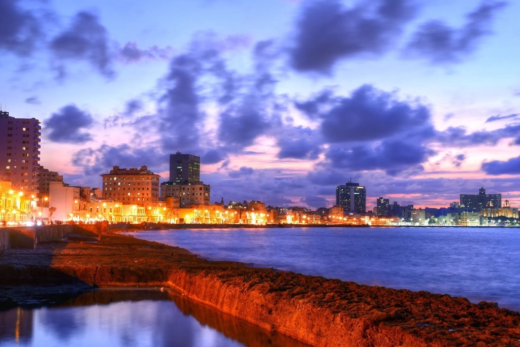 Havana Malecón waterfront at dusk with dramatic purple sky