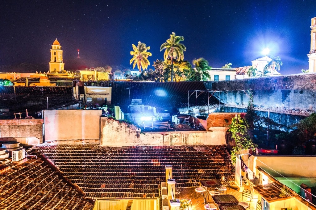 Trinidad Cuba rooftop at night with bell tower palm trees and stars