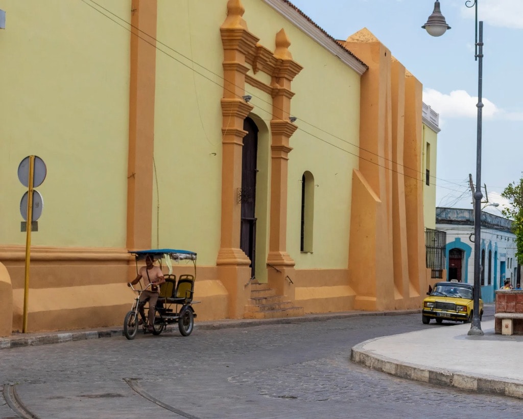 Colonial church street scene with vintage car, Cuba