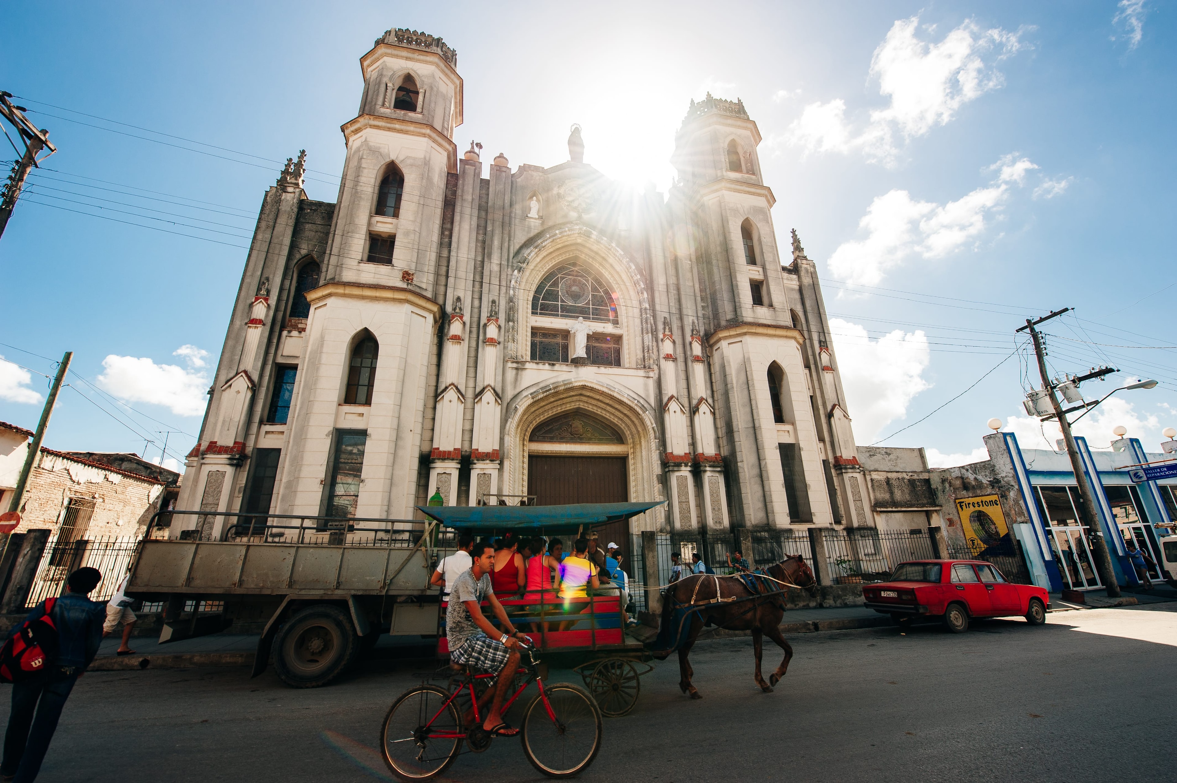 Gothic cathedral facade in Santa Clara Cuba with horse cart and bicycle taxi on street