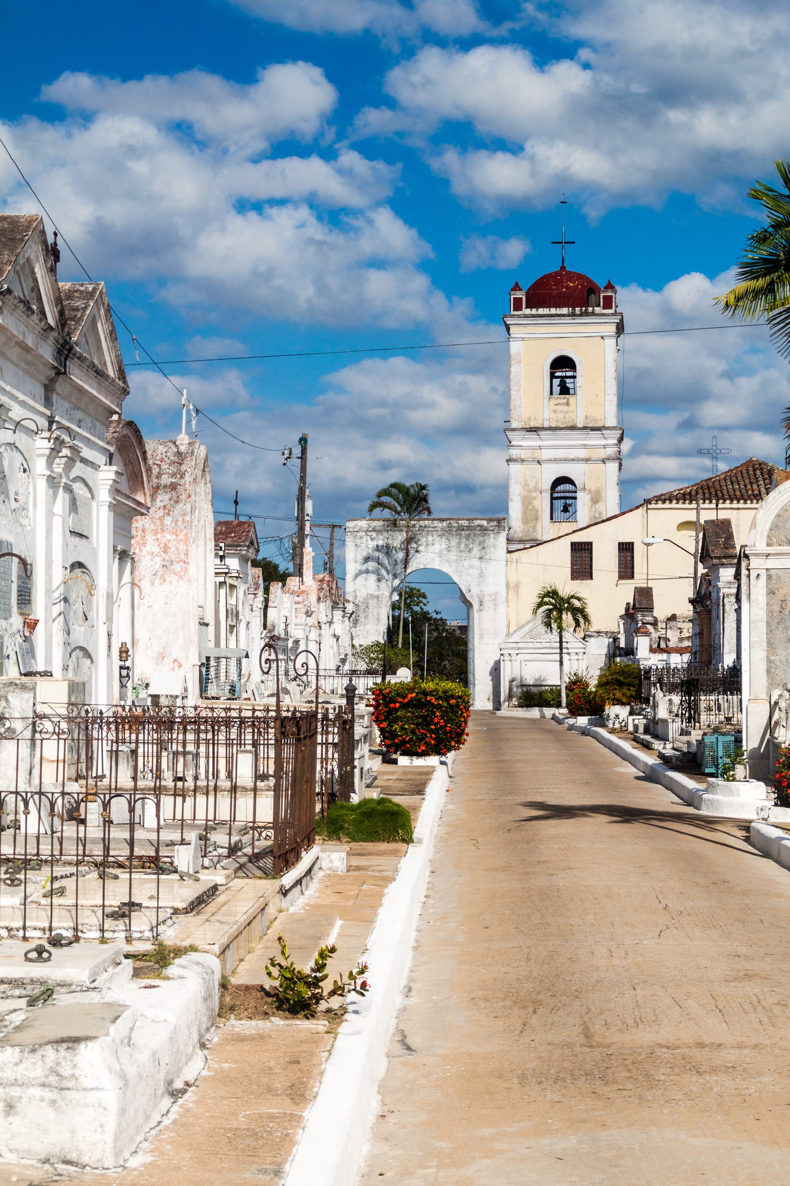 Historic cemetery with white marble mausoleums and church bell tower with red dome, Cuba