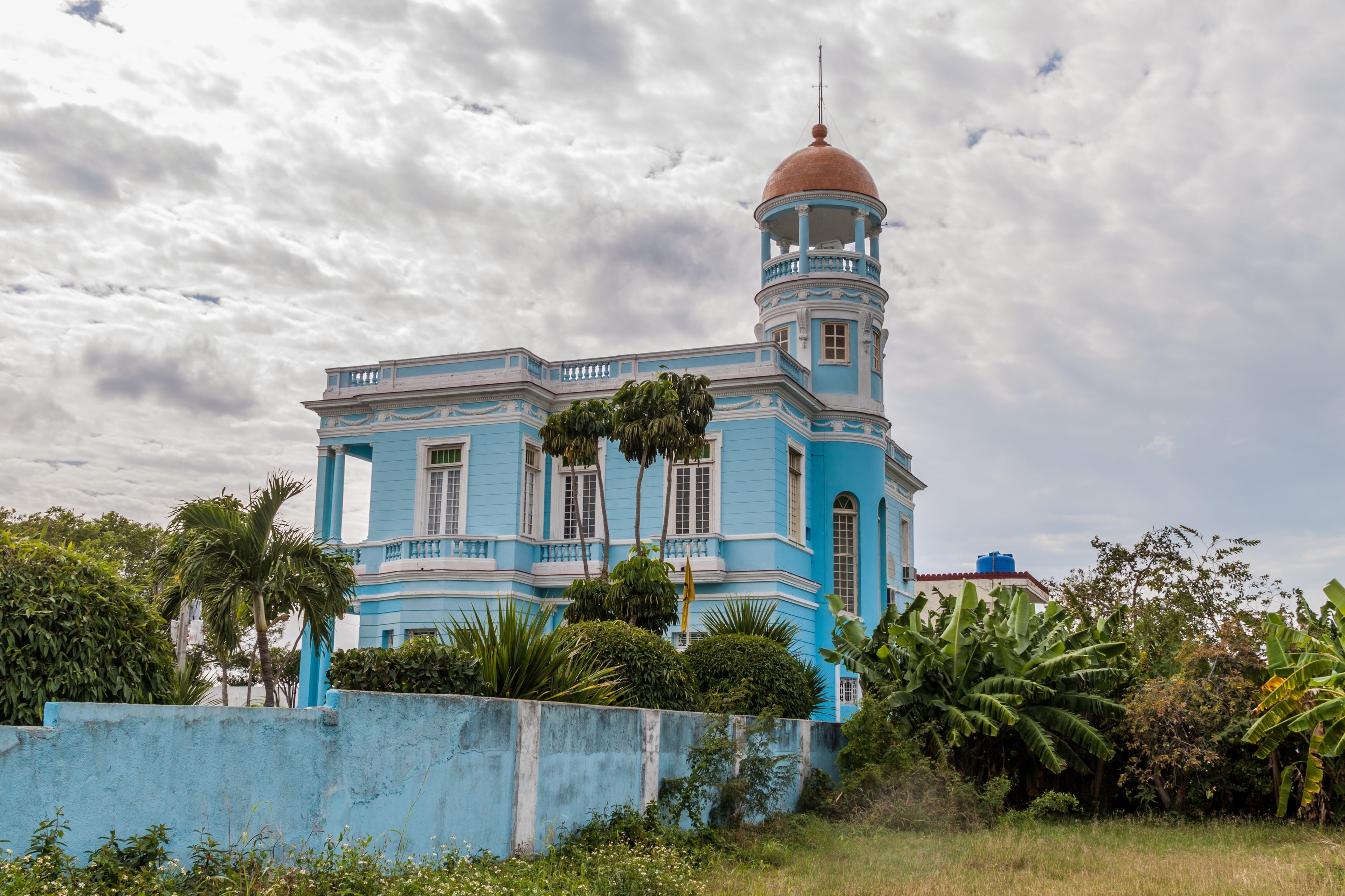 Light blue neoclassical villa with ornate tower and tropical garden, Cienfuegos Cuba